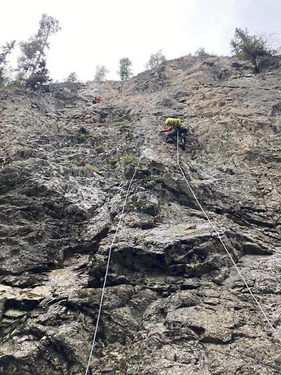 Person som klättrar i berg med skyddssele och rep
